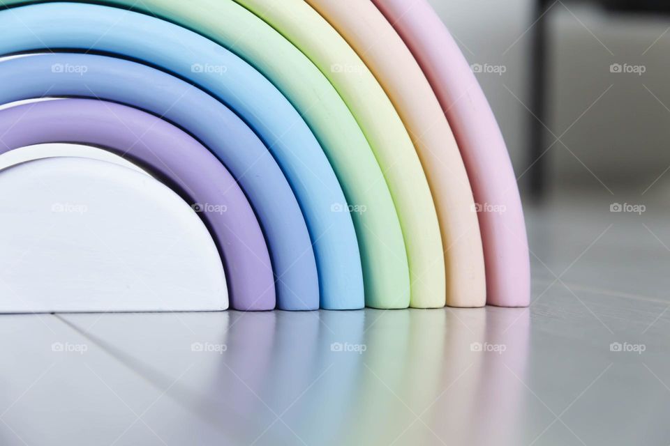 Multi-colored, wooden, toy rainbow for children's development.