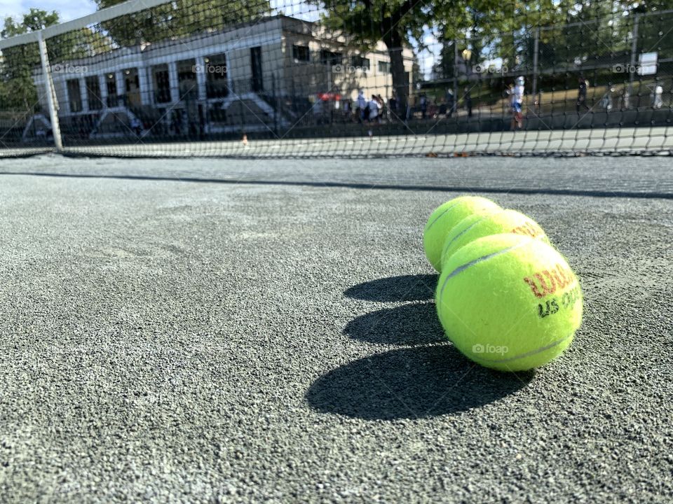 Reflection of the net and tennis balls with yellow green at tennis court Central. 