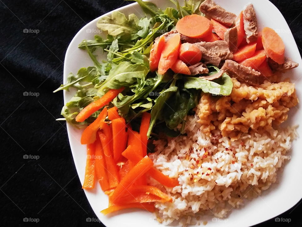 Vegan dinner of carrots, rice, arugula, peppers, lentils and "steak" strips