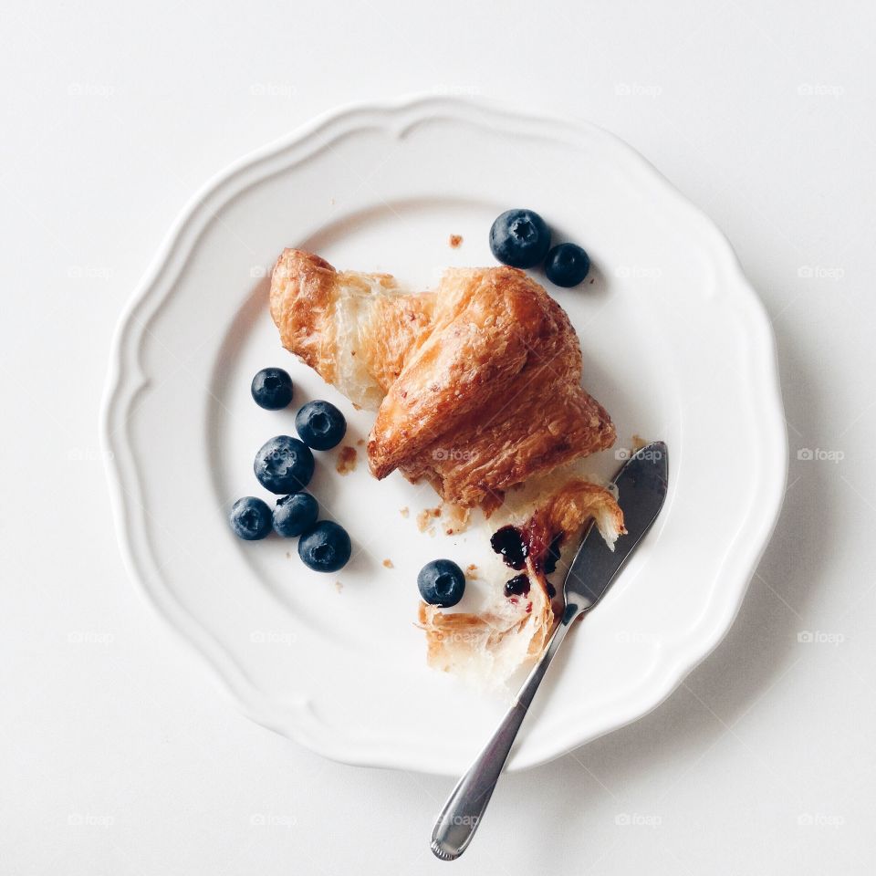 Breakfast with croissant and blueberries.