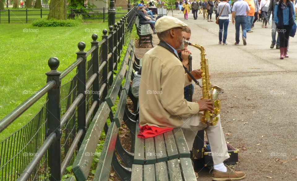 Musician playing instrument in Central Park in Manhattan New York 