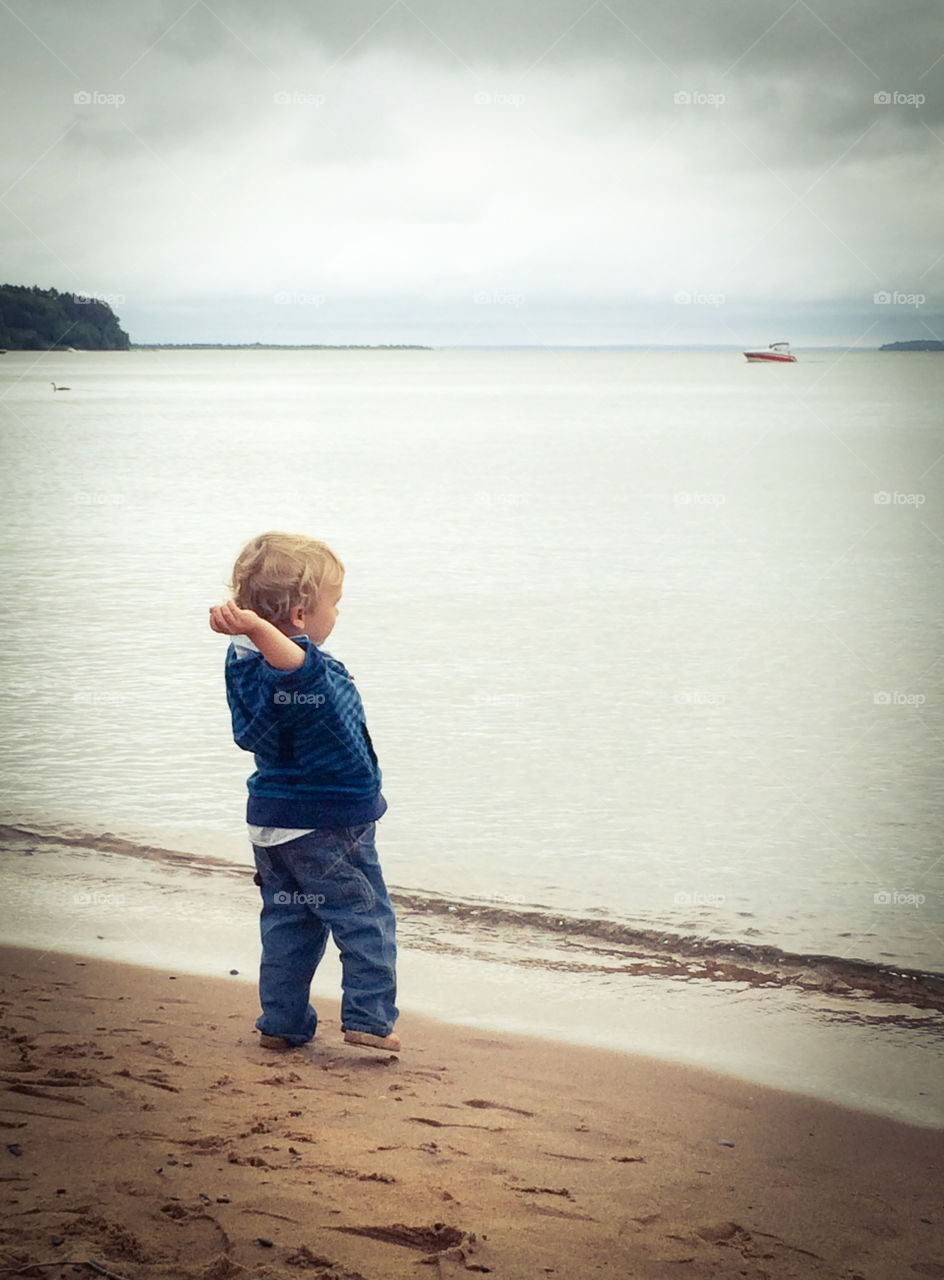 Stone's Throw. Little boy that loves beaches, boats and watching rocks hit the water's surface. 