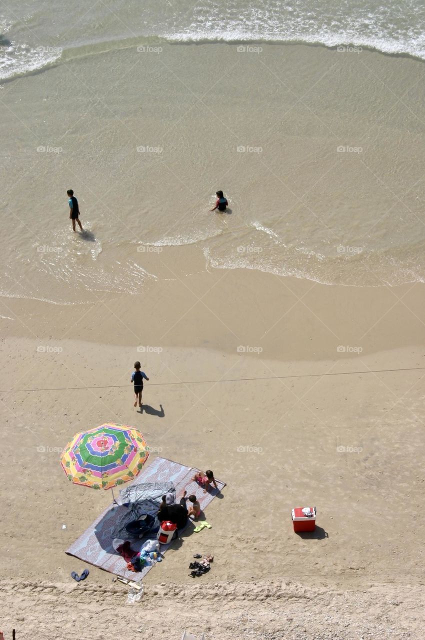 View of a beach from above with people and parasol 