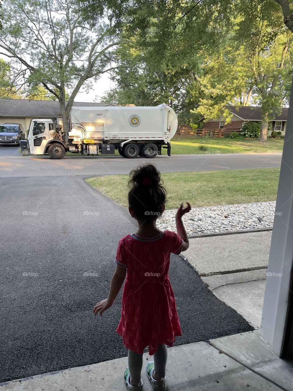 Toddler girl waves at Garbage Truck, toddlers obsessed with trucks, small child loves trucks, watching the garbage man 