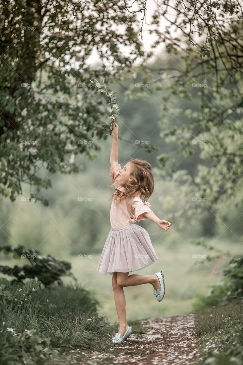 Girl in blossom garden at rainy day