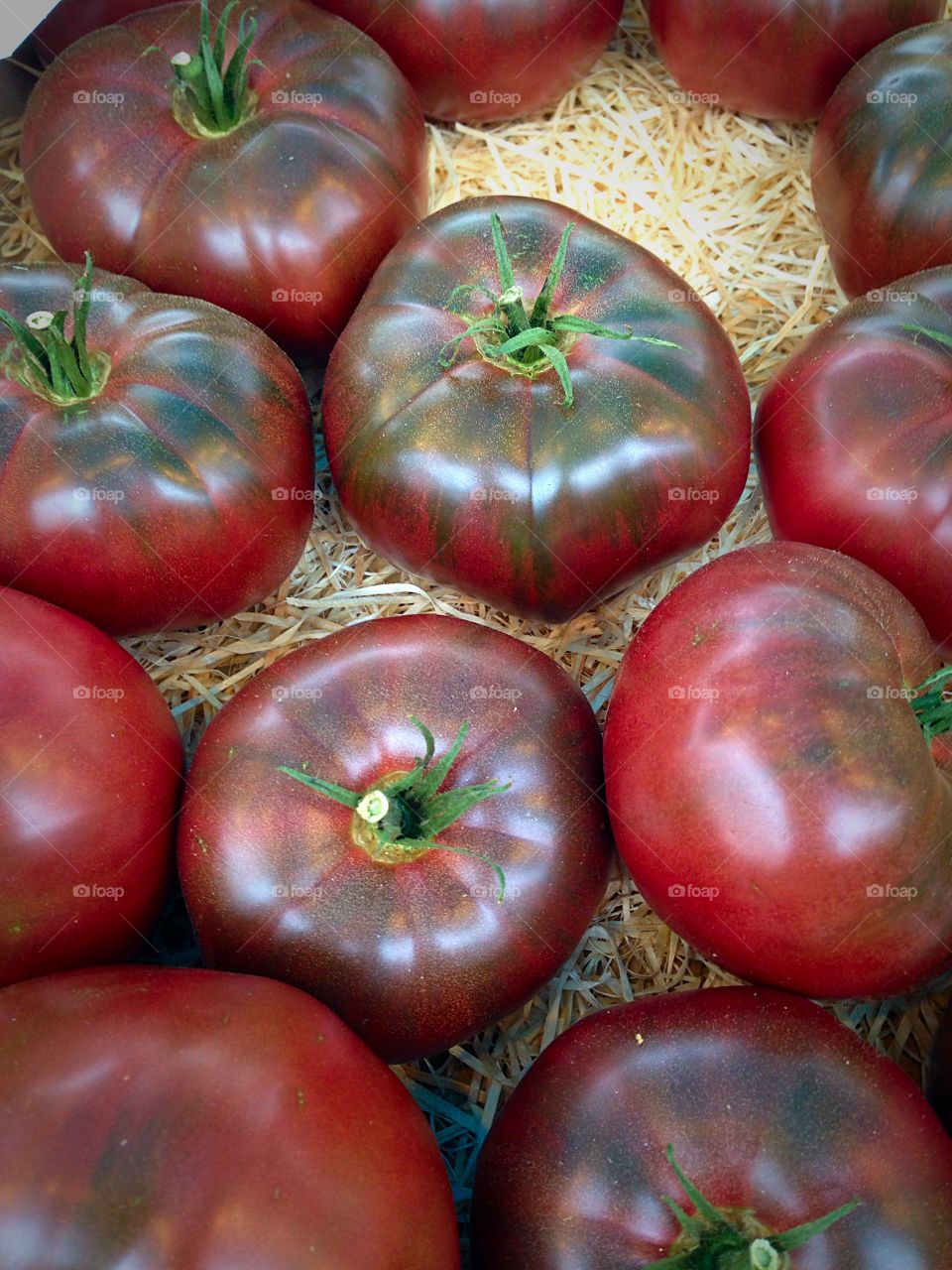 Black ribbed tomatoes on a bed of straw 