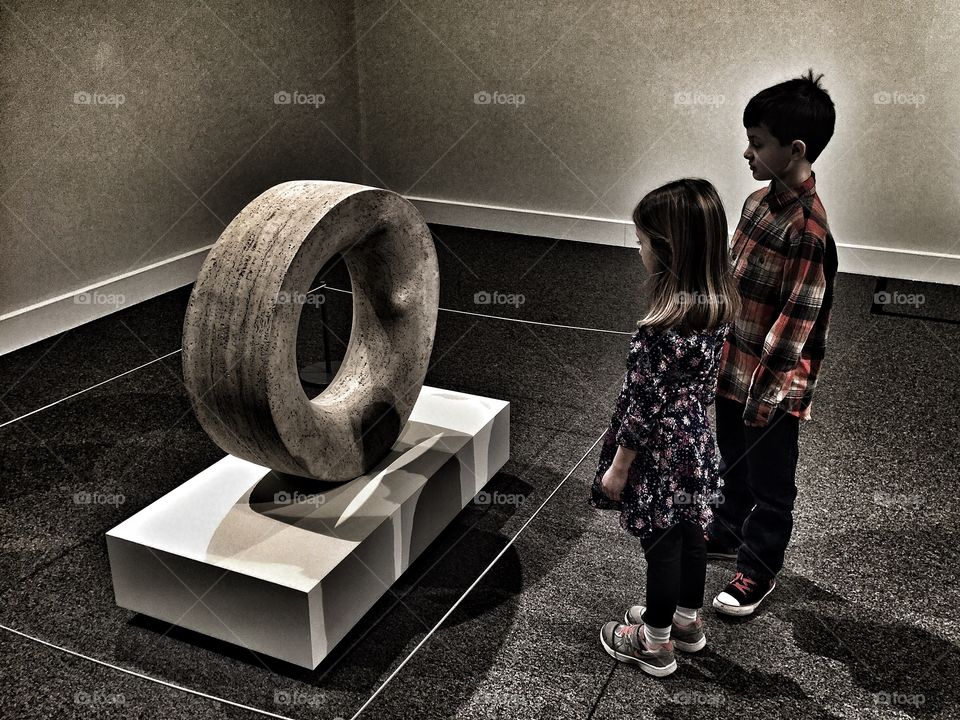 Brother sister looking at concrete tire