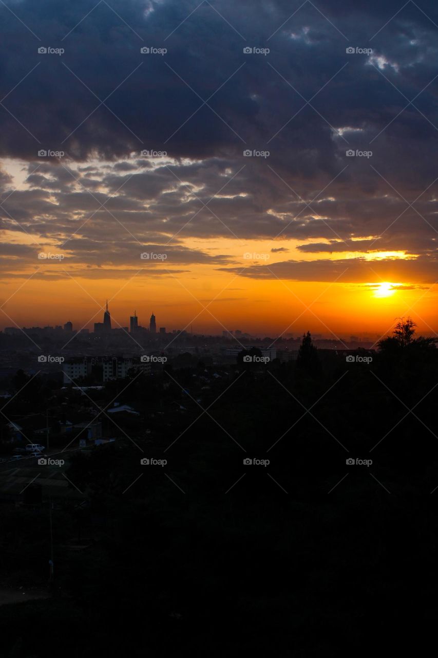 A magical sunrise in Nairobi with a view overlooking the city center. You can see some of the tallest buildings in the distance as you take in the sunrise. (Closer shot)