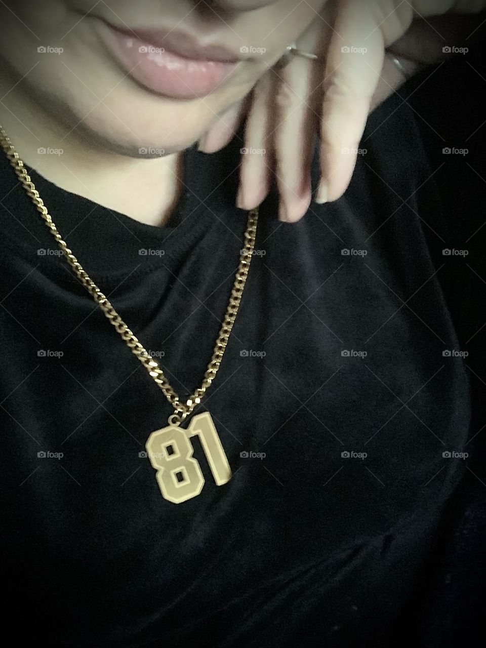 Wearing a gold “81” necklace 