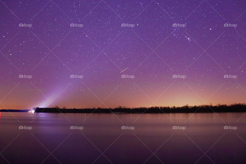 The barge shines its light up in the ski at Orion 