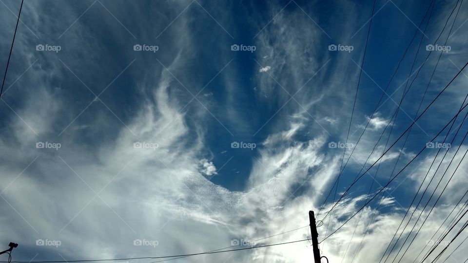 Low angle view of electricity cable against cloudy sky