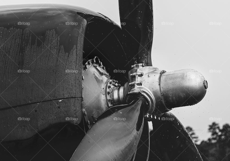 Side view of propellor and front of airplane in bnw