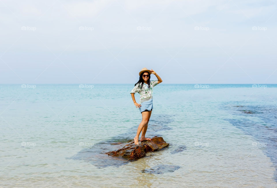 Woman standing on rock in sea