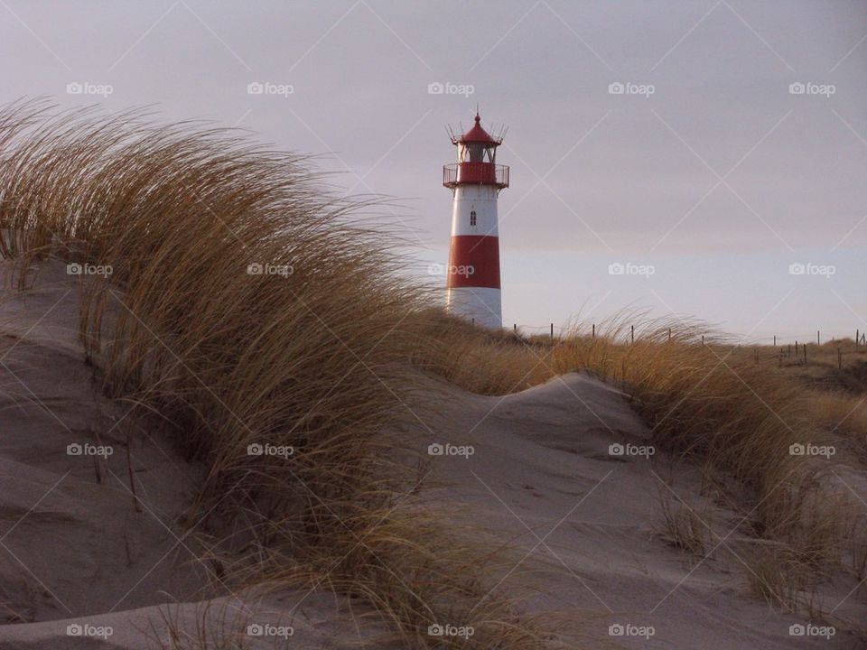 Red and white lighthouse at sea