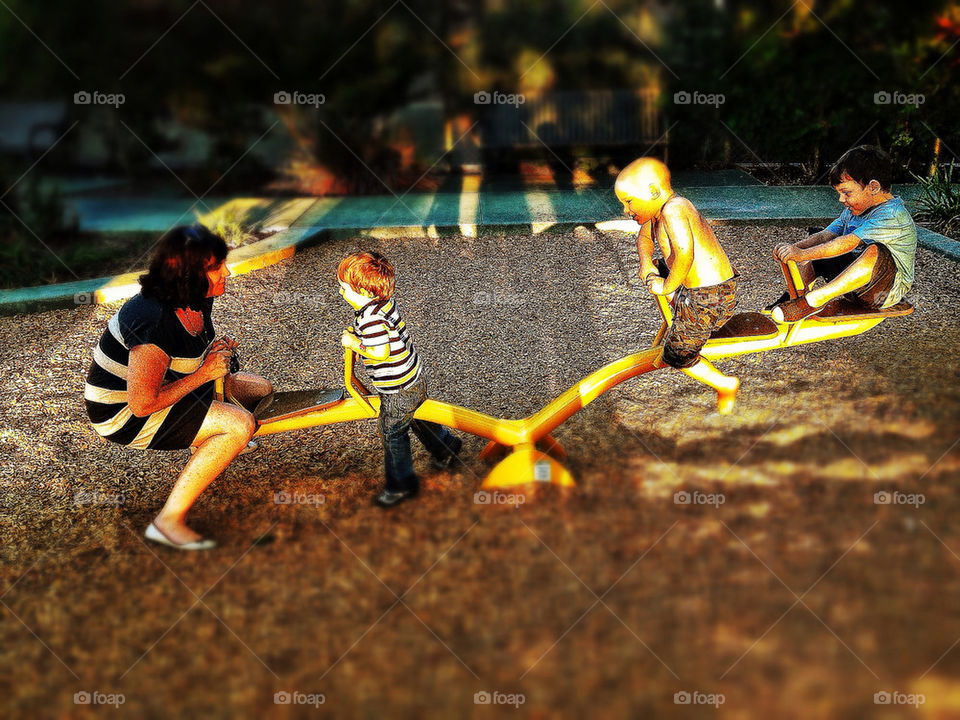 Boys playing on a see-saw in a public park in America