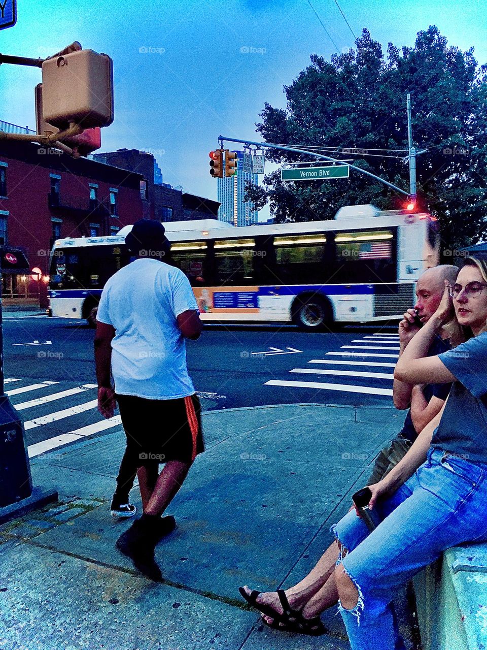 This is a casual neighborhood scene from “Vernon Jackson Avenue” and “48th Street” in LIC, Queens next to the Mexican taco stand. People are either walking by or leaning up against the banister waiting for their order. 2021. Hypnotic Productions