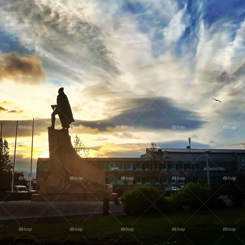 As the sun comes up over Hallgrimskikur the popular church in Reykjavik, Iceland. The statue of Leif Ericsson stands tall and proud ,majestic watching over this land of rough beauty.