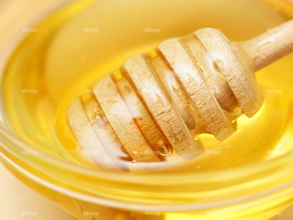 Close-up of honey drizzler with gold coloured honey