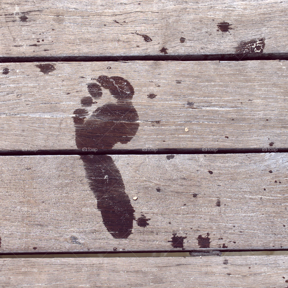 High angle view of wet footprint on wood