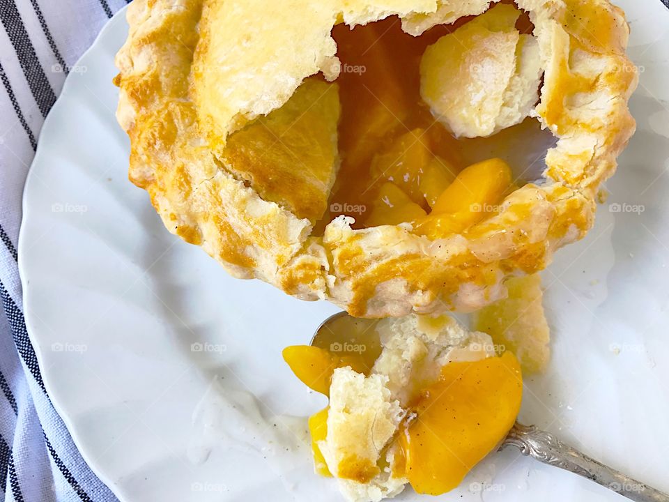 Small peach pie with spoon