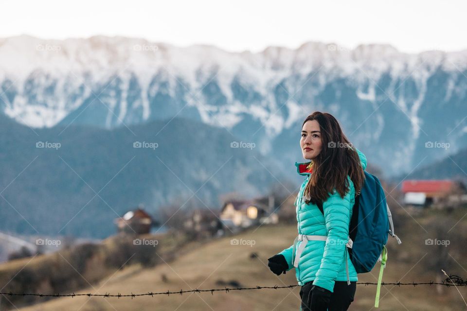 Beautiful woman while being on a hike stopped to see the sunset. 