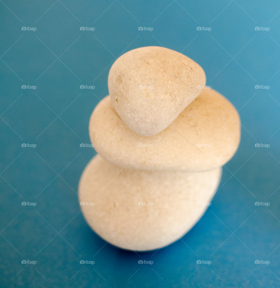 Stack of white rocks on blue background