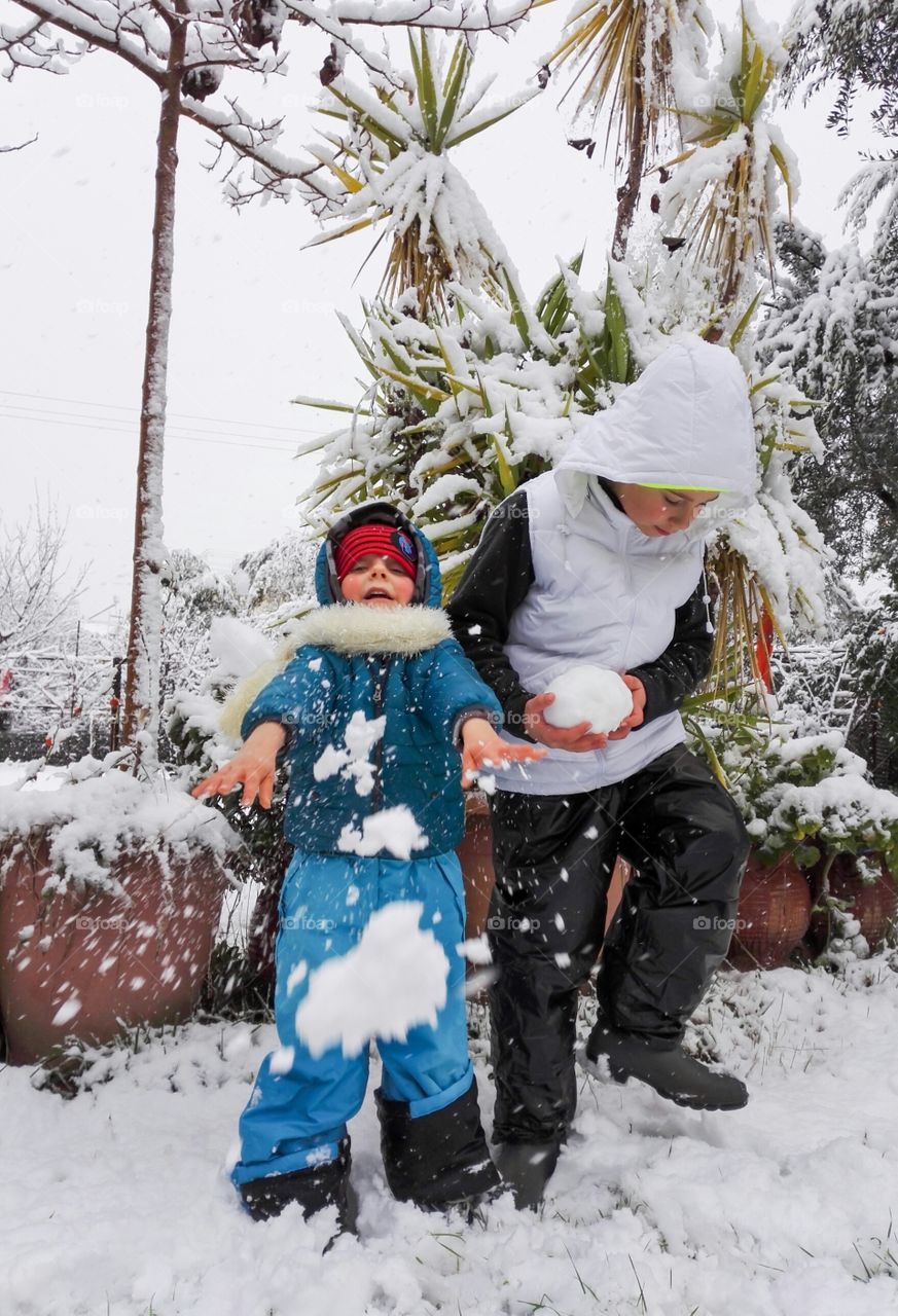 two children playing with snow