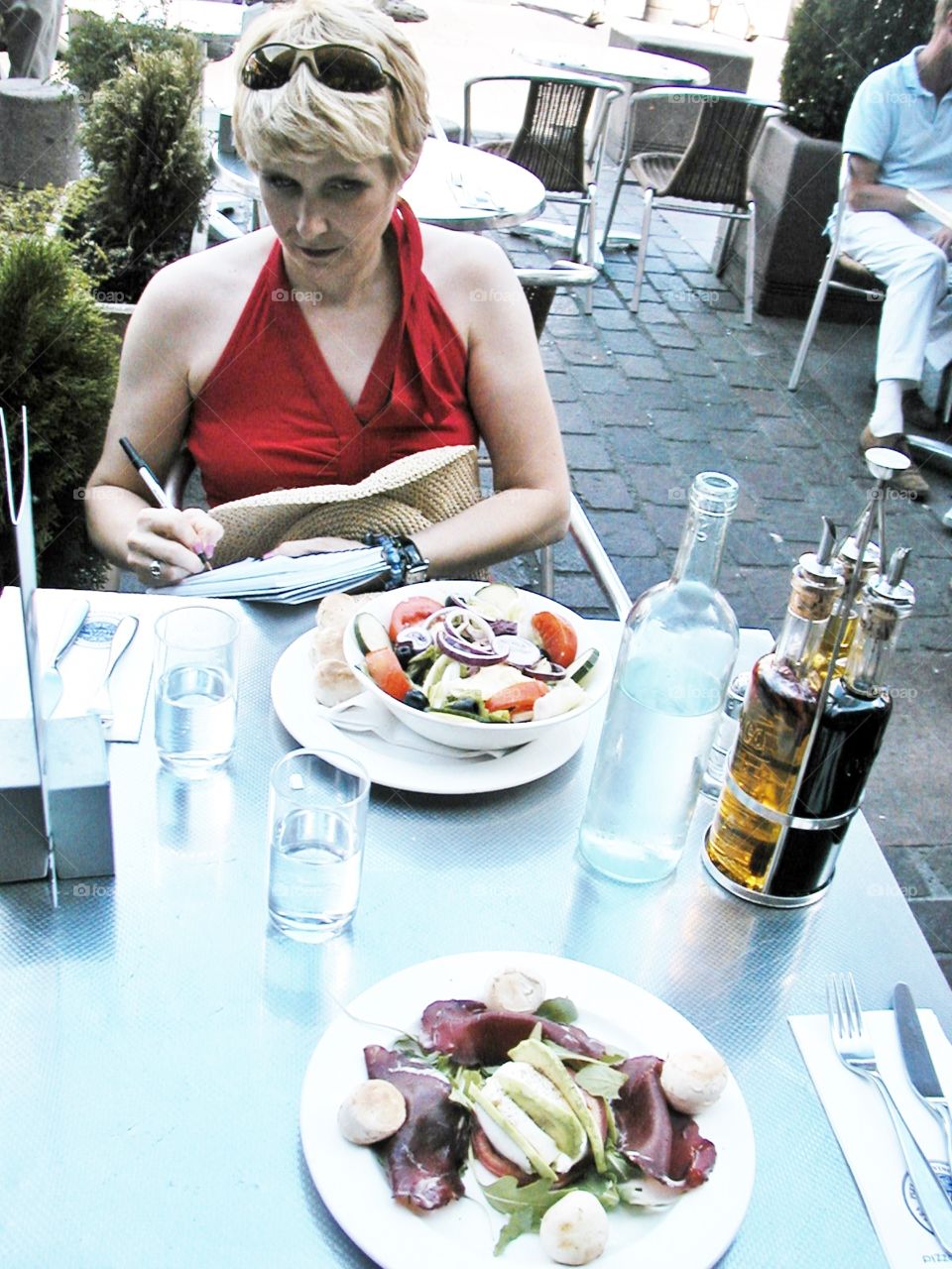 Outdoor French cafe. Taking travel notes during a salad luncheon at an ourdoor cafe in Tolouse, France