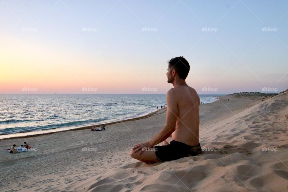 Moment of stillness, father meditate on the beach