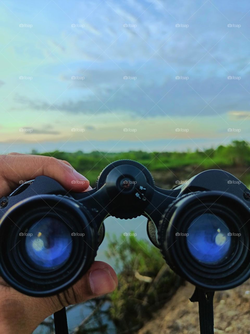 Hand man hold binoculars on a beautiful day on the river, binoculars sailor