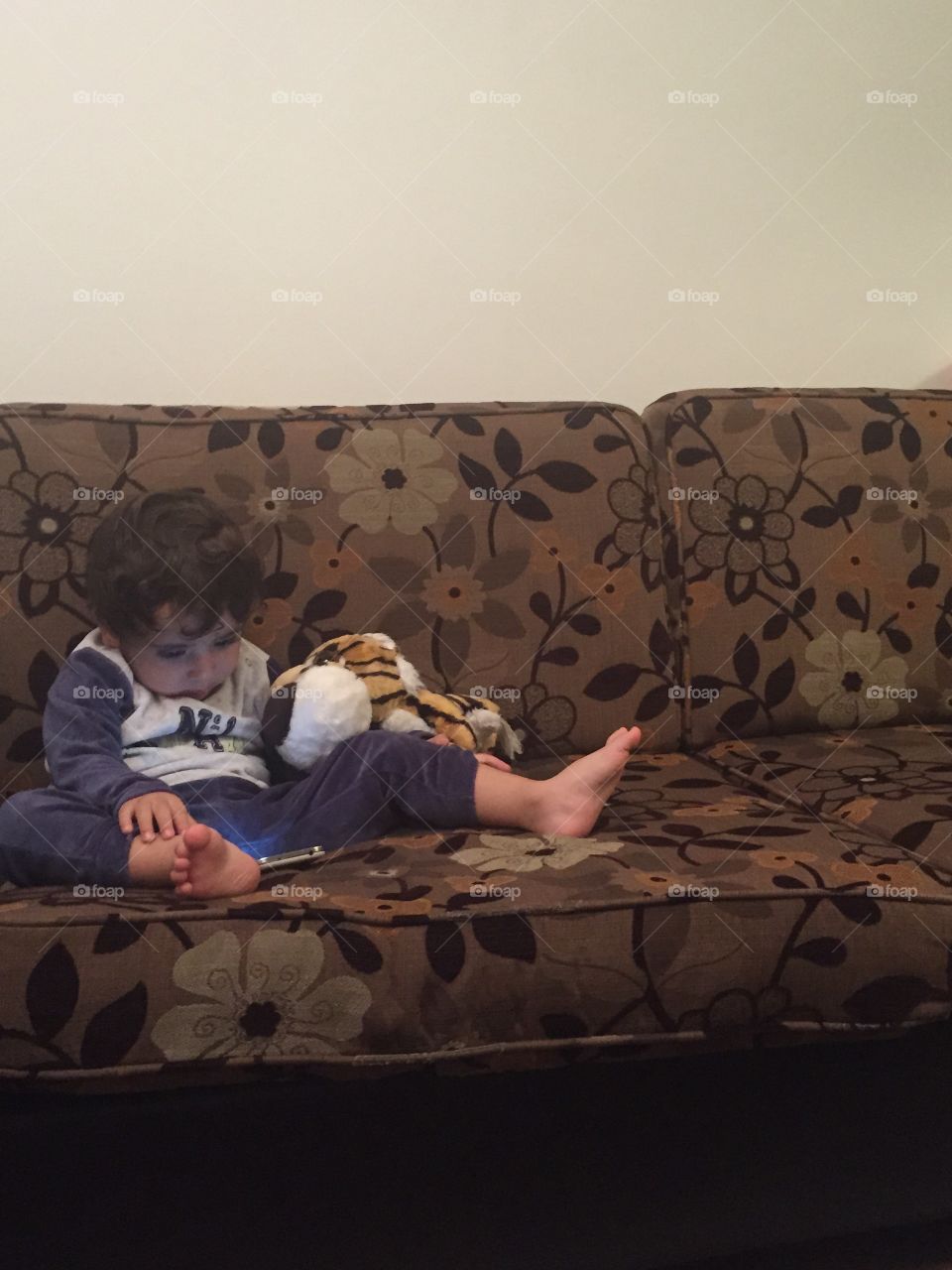 Baby boy on sofa with teddy bear