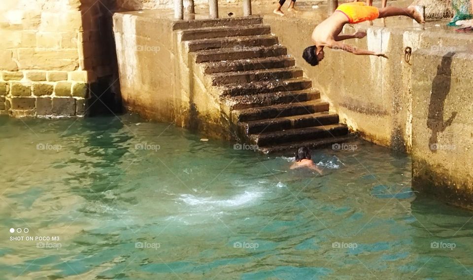 splendid jump into water at essaouira Harbour in Morocco.