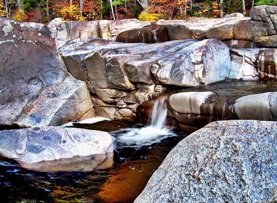 mountain waters flowing. Along the Kancamagus  highway in the White Mountains of New Hampshire, gentle waters run over the rocks.