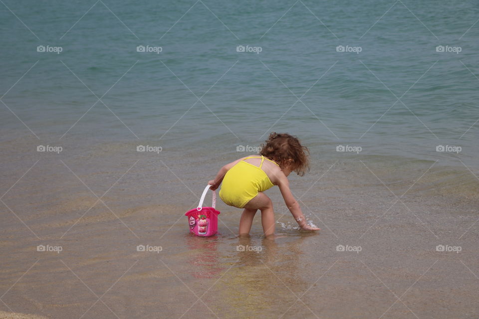 Little girl checking the water if it is warm enough to swim - or just playing in the shallow... 😊