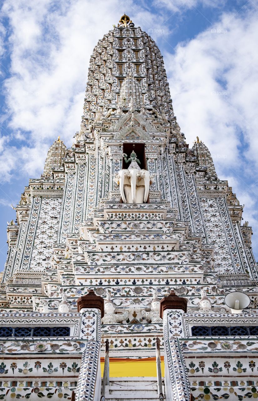 Create photo view of the most famous pagoda of  Temple of  Dawn (Wat Arun) on blue sky background in Bangkok Thailand 