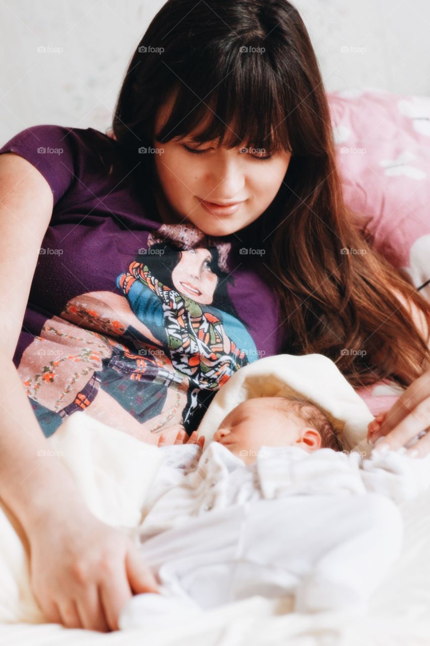 Young mother looking at her sleeping baby