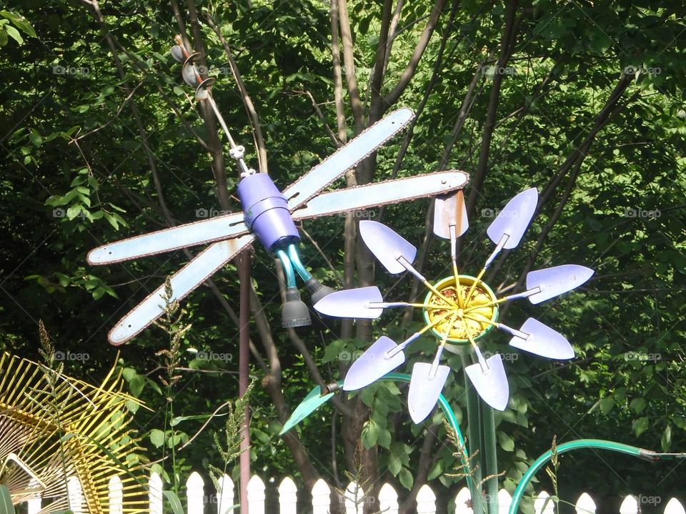 Dragonfly and flower sculptures made from gardening equipment