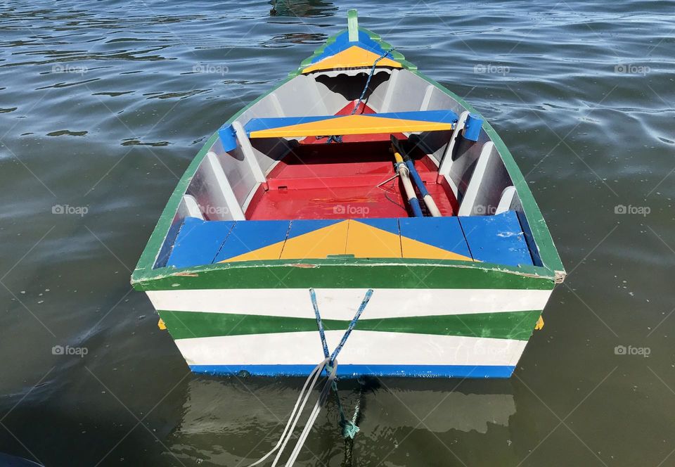 a small colorful boat on the seashore