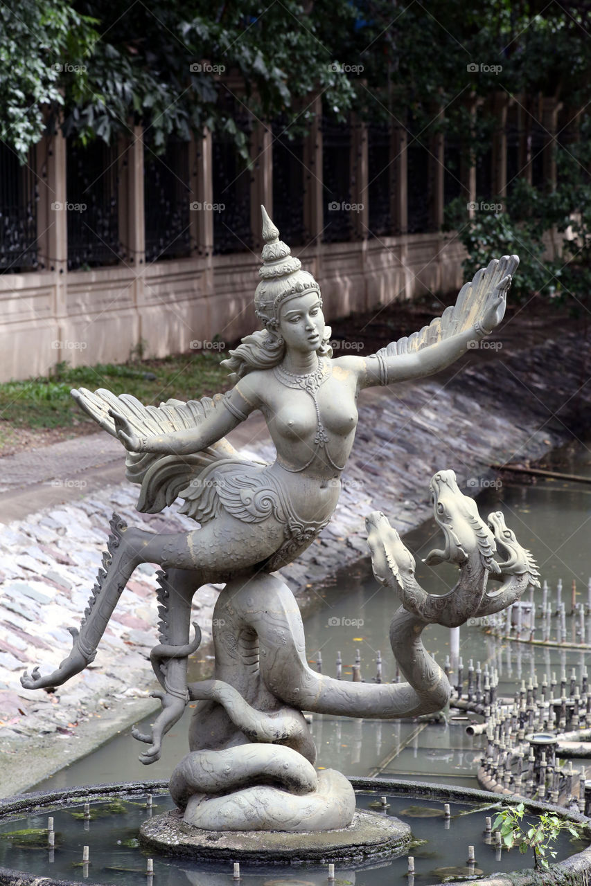 Winged Goddess and the Dragon. She guards one of the royal residences in Thailand, standing watch as the traffic drives by
