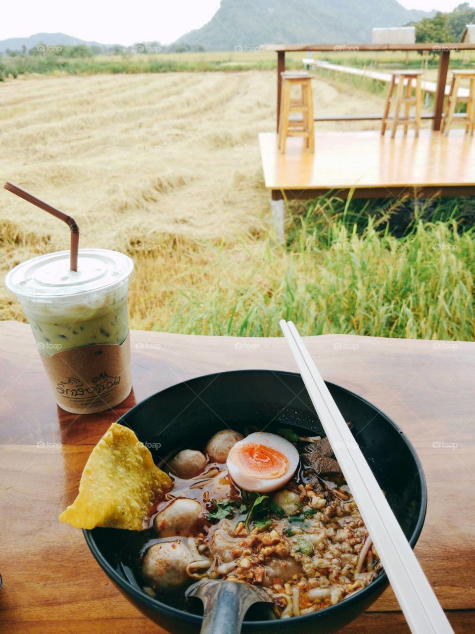 Tom Yum Noodle with Ice Green Tea in the rice field.