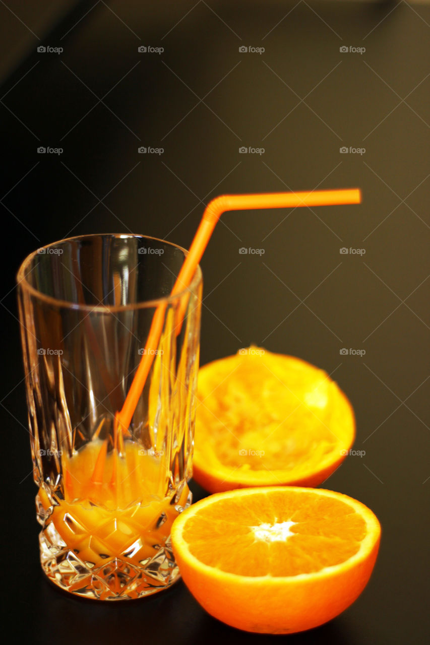 Close-up of halved orange and glass