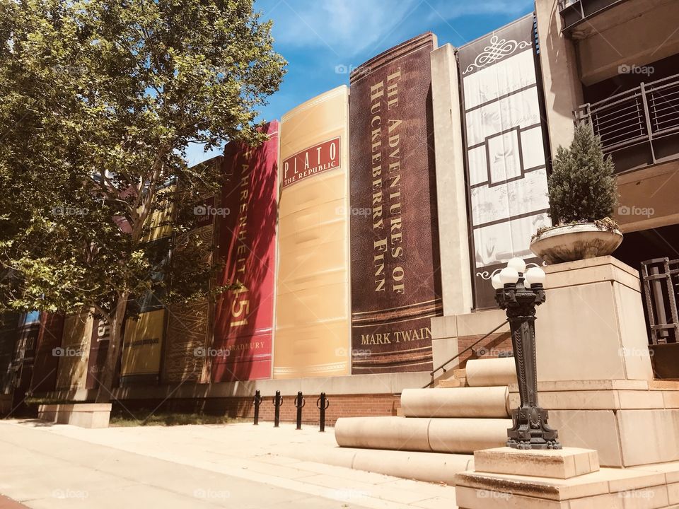 Gorgeous wall mural on library in Kansas City, MO of books lined up and the building is even complete with books stacked on each other for steps!! 
