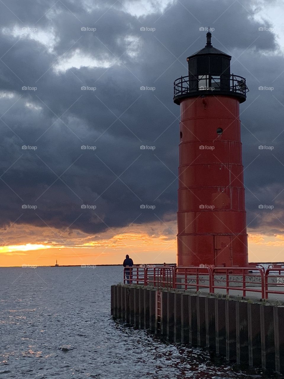 Red lighthouse with stormy skies at sunrise