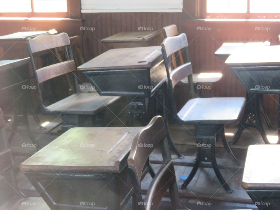 Sunlight bathes the desks in the old schoolhouse.