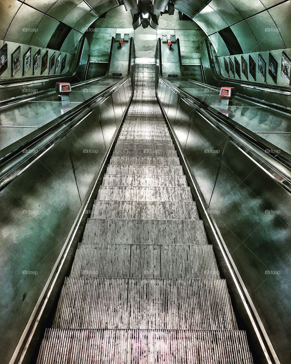 London underground escalators taken with dynamic lighting to add depth and drama coupled with the simple symmetry. 