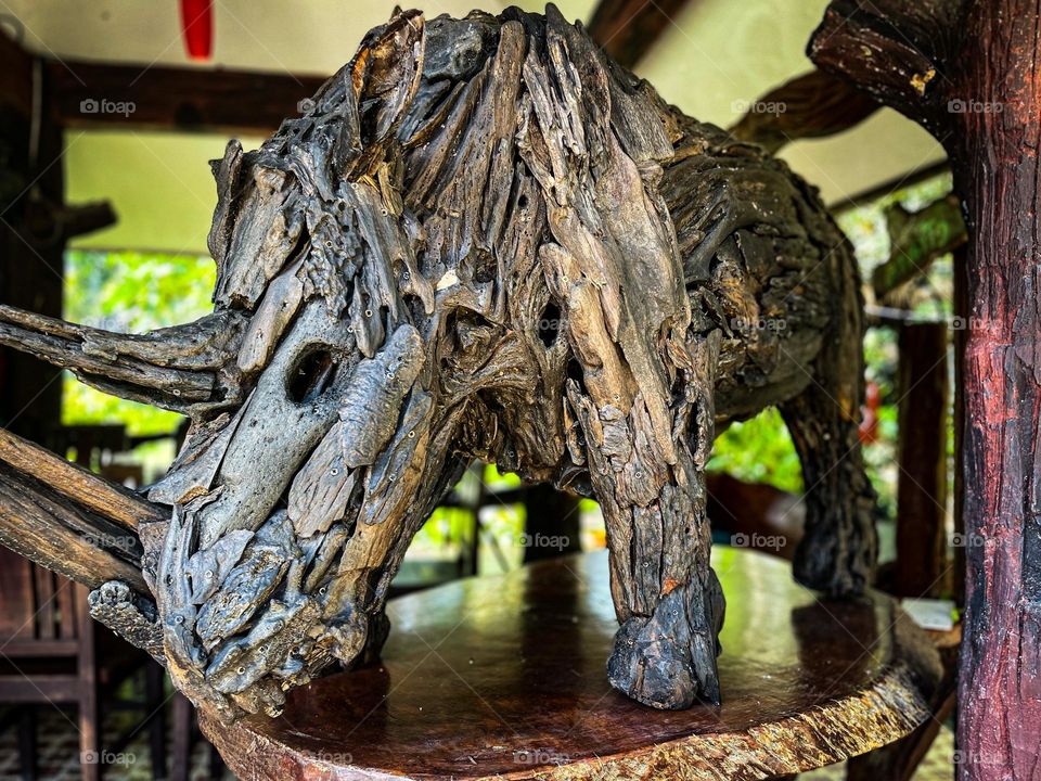 A mighty drifted wood sculpture of a rhinoceros in close up view