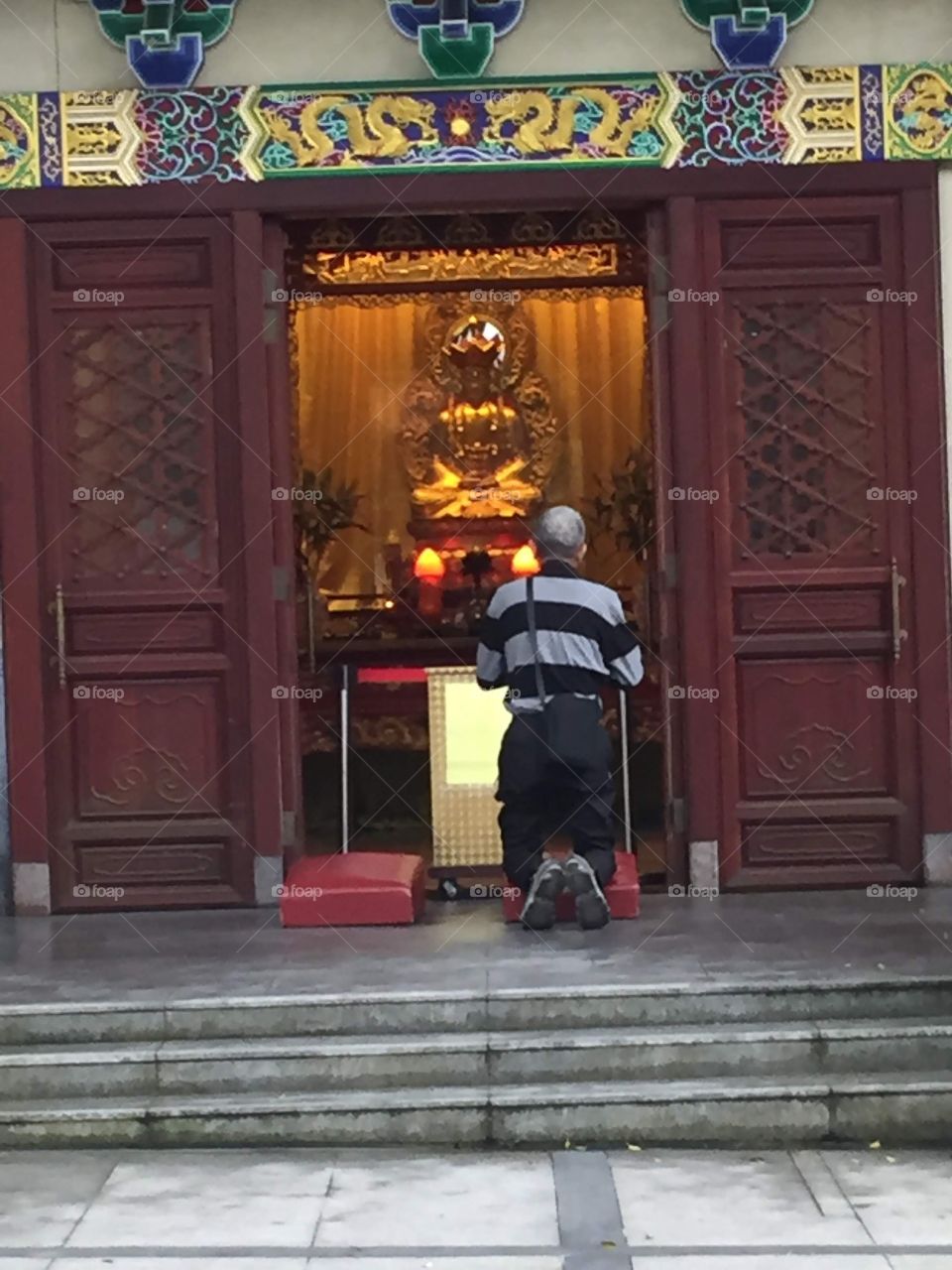 A man praying to Buddha. Buddha Shrine. Ngong Ping Village, Po Lin Monastery, Lantau Island, Hong Kong. 