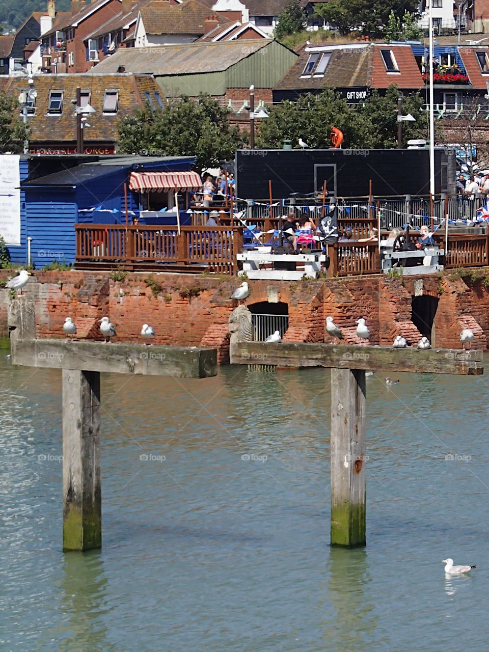 Tourists enjoy a sunny summer day along the bay while on vacation in Folkestone in England 