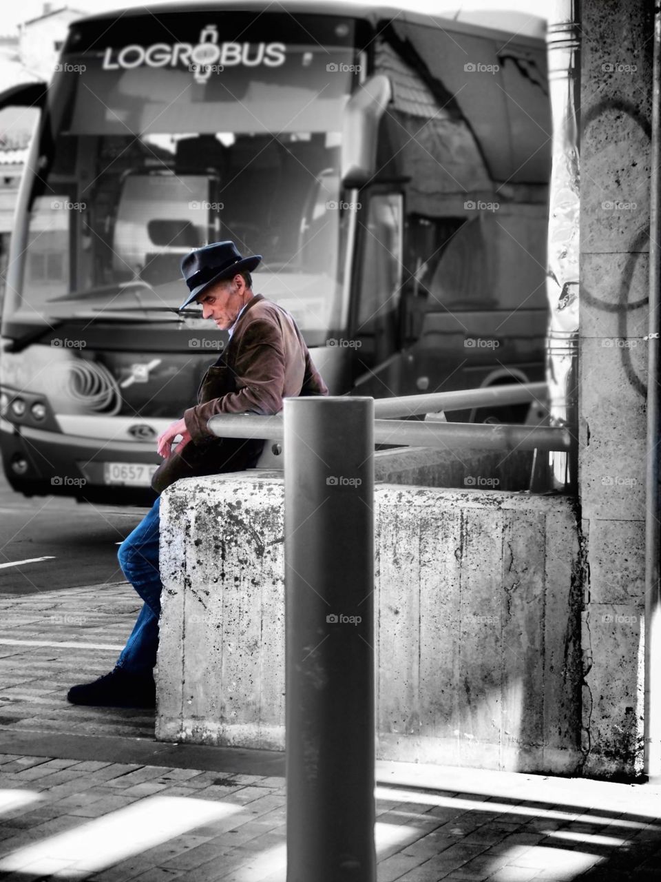 Old man waiting, Man looking at watch, Man waiting at bus stop, Man waiting on wife, Man waiting outside, Color versus black and white, Contrast of color and black and white, Elderly man waiting at bus stop