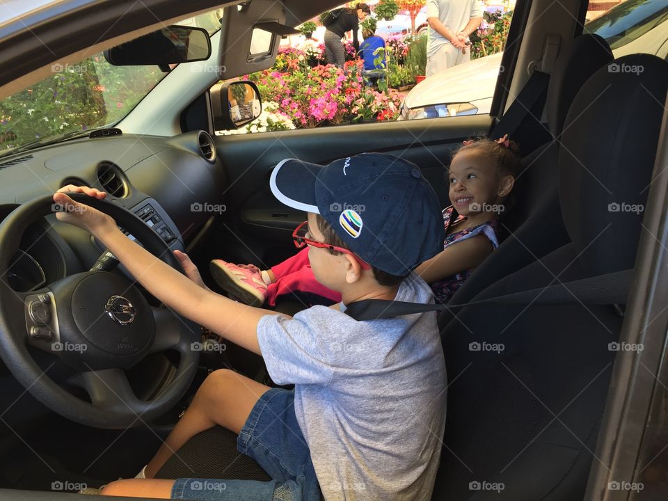 Brother and sister sitting in car